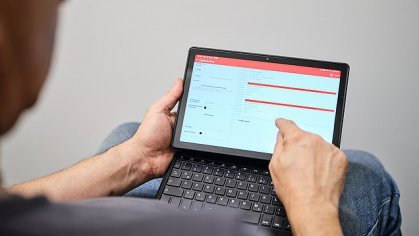 Photo over the shoulder of an employee operating a tablet