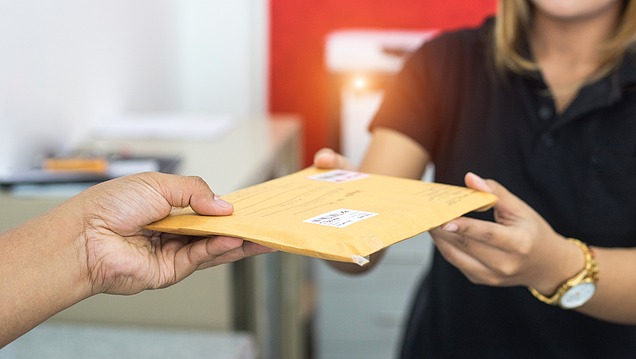 Picture of an envelope being handed over to another person