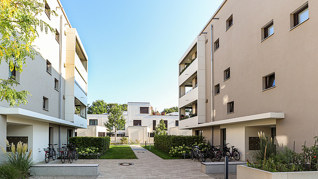 Modern and bright residential complex with new-build apartment buildings, landscaped raised beds and areas.