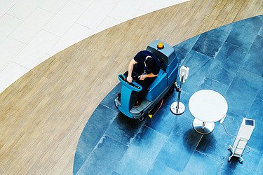 Picture of a floor cleaning with a ride-on machine