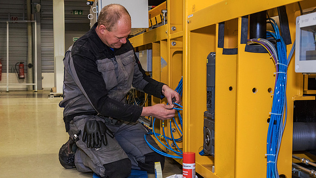 Picture of a man repairing cables on a system