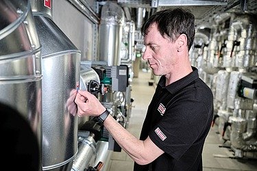 Picture of an employee attaching a maintenance sticker to a technical system