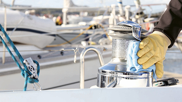 Picture of a hand with a cleaning cloth used to clean a part on a boat