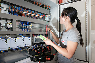 Photo of an employee carrying out measurements on a control cabinet