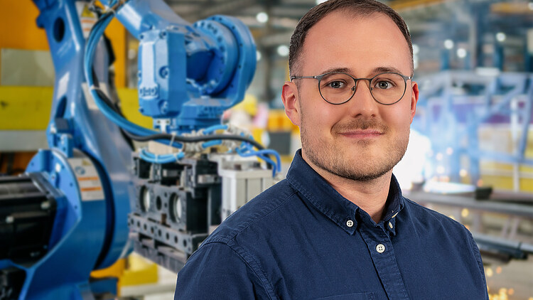 Picture of a man standing in front of a production machine