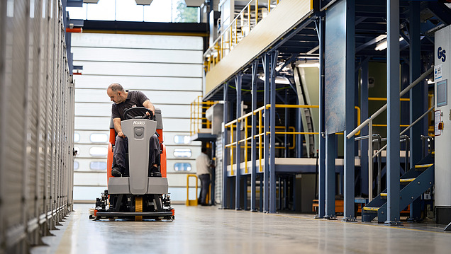 Image of floor cleaning using a ride-on cleaning machine in a hall