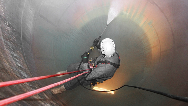 Image of an industrial climber abseiling into a silo