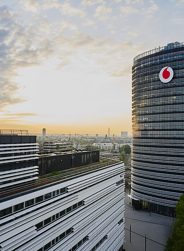 Bild von einem Hochhaus mit Vodafone Logo vor einem Wolkenhimmel