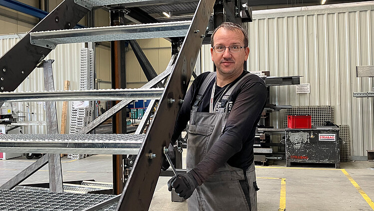 Picture of a man screwing on a metal staircase