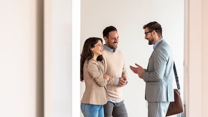 Three people in conversation in a light-flooded room.