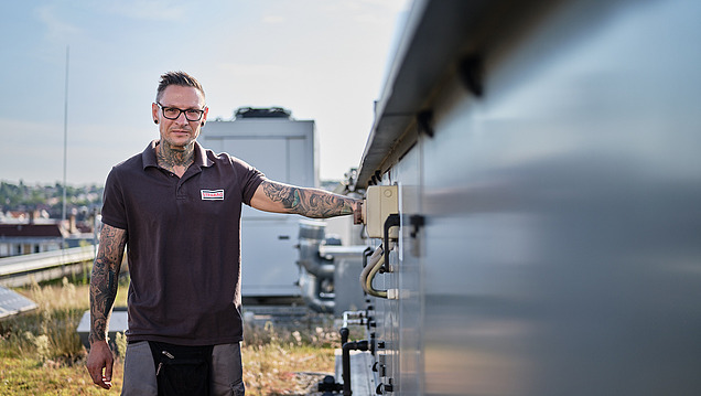 Picture of an employee standing next to a photovoltaic system