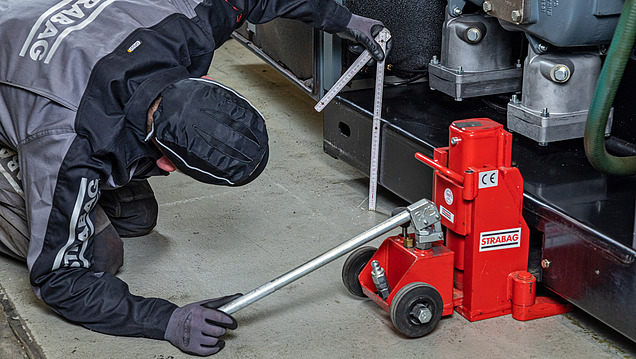 Image of a person carrying out a disassembly using a jack