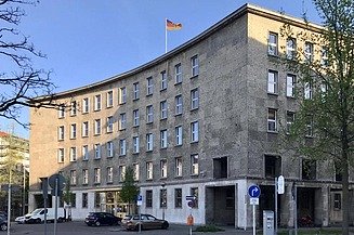 Photo of a curved building with a German flag on its roof