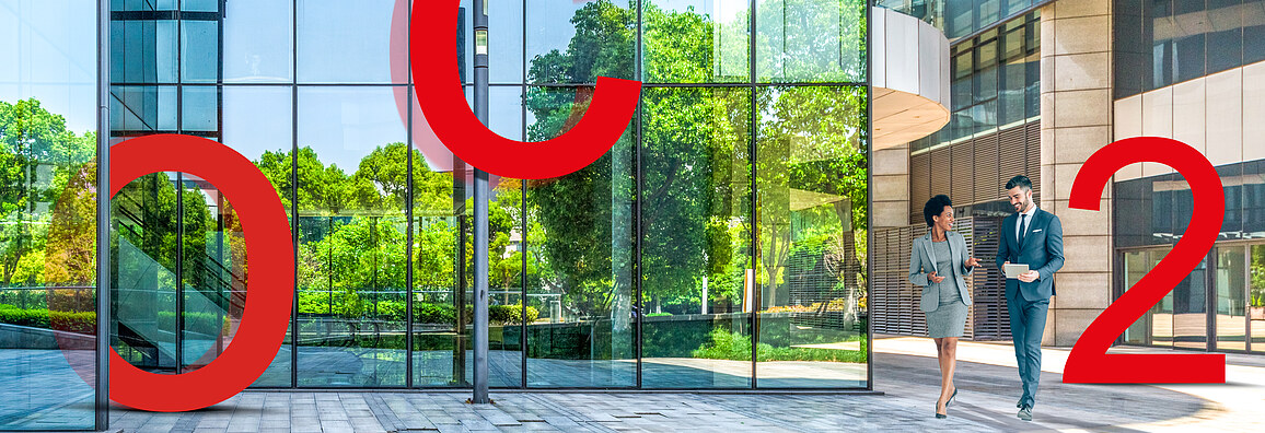 Image of large red letters O, C and 2 in front of a glass façade